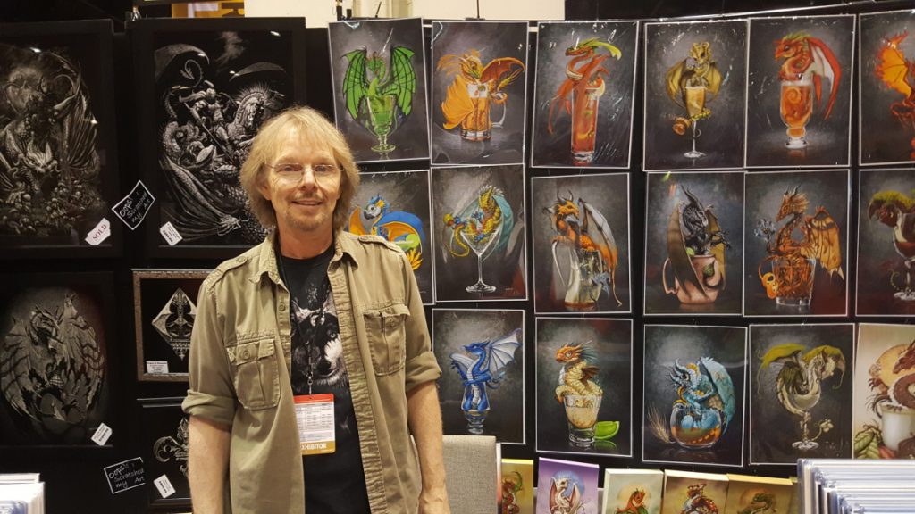 Stanley Morrison standing with his art at MegaCon 2018.